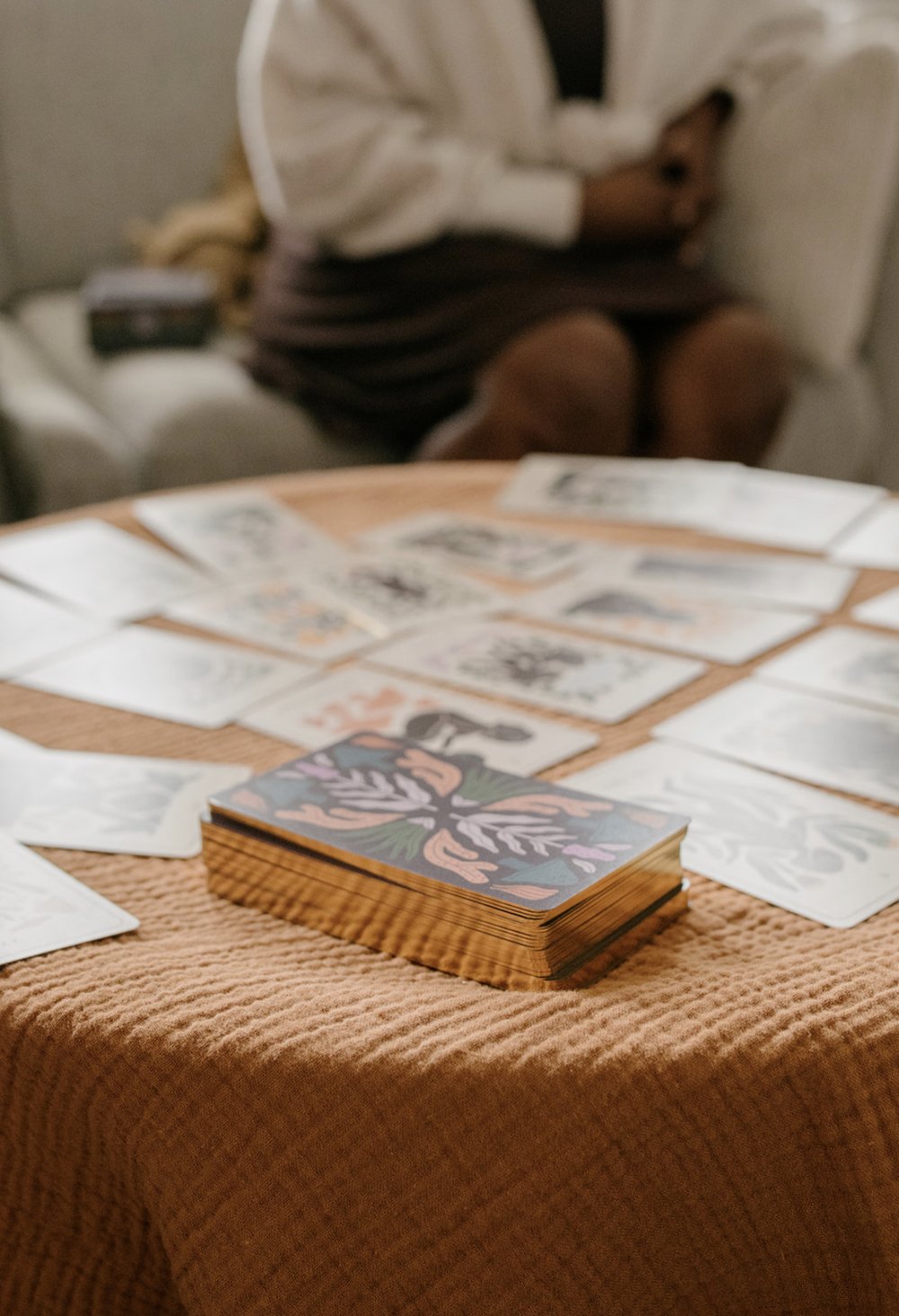 Close-up of the Be With Your Body Tarot deck resting on the reading table