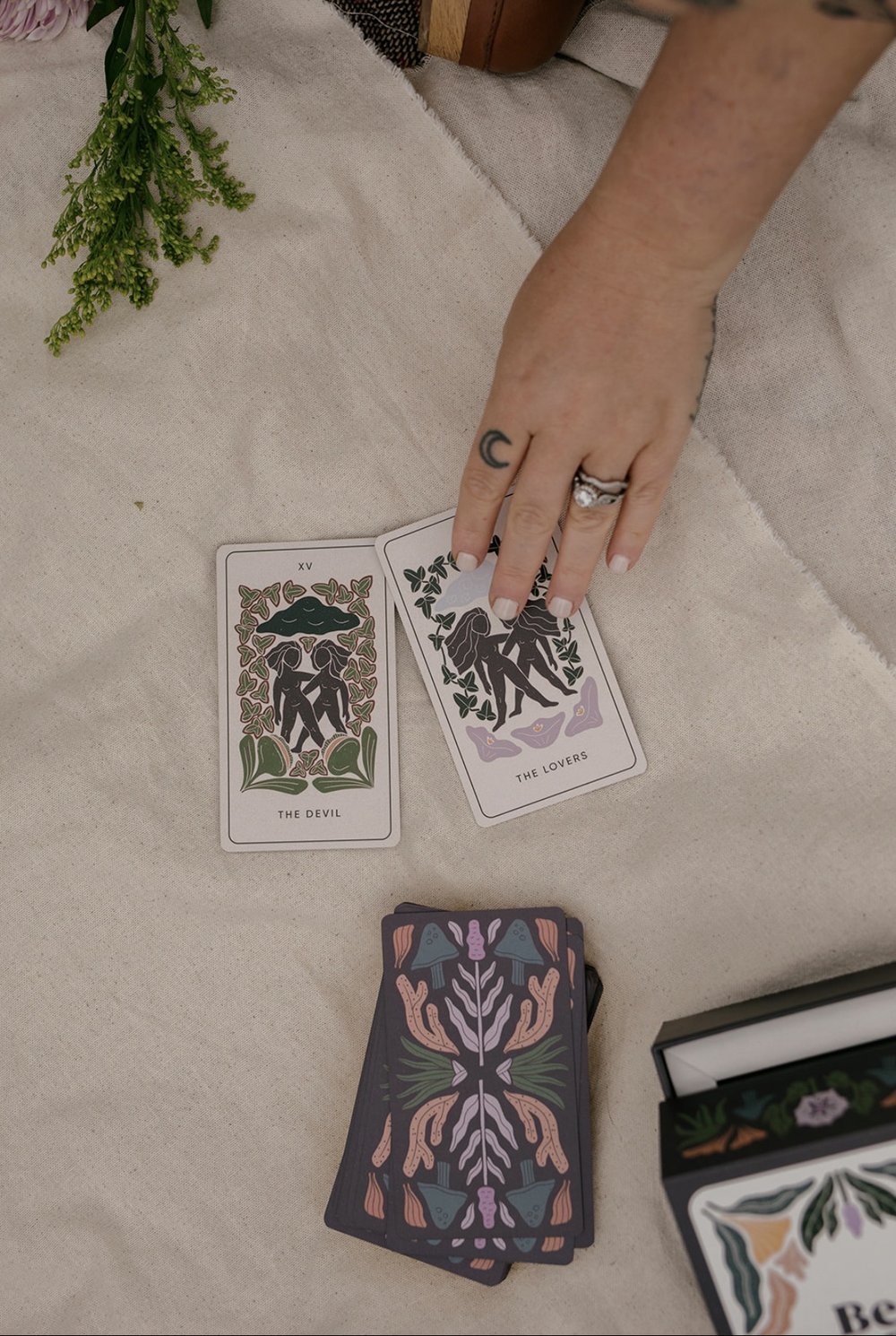 A tarot reading laid out on a picnic blanket among fresh flowers